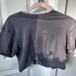 Grå croppad t-shirt från Bik Bok - Säljer en enkel grå croppad t-shirt från Bik Bok. T-shirten har korta ärmar och en avslappnad passform. Perfekt till jeans eller shorts för en chill look. Sista bilden kan man se att den har ett litet hål på framsidan av tröjan men detta syns knappt! ❤️