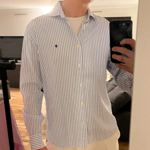 Morris Skjorta - Tja! Säljer en riktigt snygg Morris skjorta. Den är i väldigt bra skick 10/10. Skjortan är i färgen vit och blå. Storlek L men passar stor M. Den är perfekt nu till våren och sommaren☀️ Nypris runt 1800 kr Hör av dig vid funderingar🙌