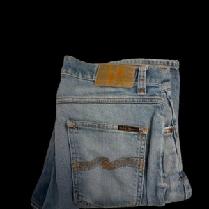 Nudie jeans - Ljusblå nudie jeans | storlek W29 L30 | modell vet inte riktigt men skulle tro grim tim | slitage i skrevet som är reparerad (se bild 3)