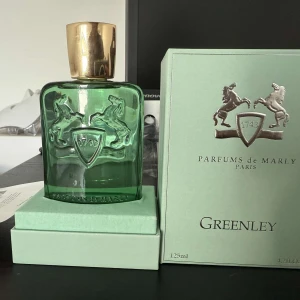 Greenley Eau de Parfum från Parfums de Marly - Greenley från Parfums de Marly är en exklusiv parfym i en stilren ljusgrön kartong med silverdetaljer och logotyp med två hästar. Flaskan rymmer 125 ml och doften är känd för sin fräscha och grönskande karaktär.