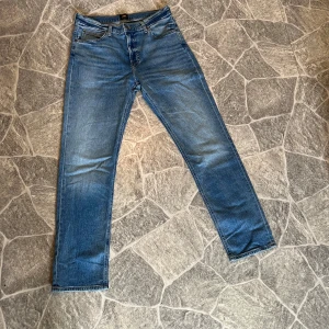Blå jeansbyxor från Lee -  Blå jeans från Lee. Byxorna har straight passform och är tillverkade i slitstarkt denimtyg. Nästan helt nya, (använda en gång) nypris 800. Storlek 33/32