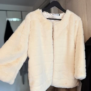 Beige pälsjacka från Missguided - Säljer en fluffig och mjuk beige pälsjacka från Missguided. Jackan har rund halsringning och långa ärmar. Perfekt för att lyfta vilken outfit som helst med en lyxig känsla. Oanvänd 
