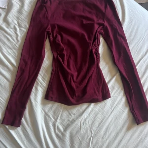 Röd långärmad tröja - Säljer en röd båtringad långärmad tröja från stradivarius. Den har scrunch på sidorna som följer figuren. Storlek XS, skulle säga att det passar S med. Den har använts en gång och är i fint skick utan defekter.