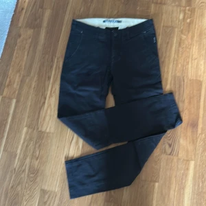 Svarta chinosbyxor från WINWIN köpt på Carlings - Säljer ett par svarta byxor från WINWIN i storlek XS. Byxorna har en klassisk femficksdesign, normal passform och är tillverkade i bomull med lite stretch för extra komfort. Perfekta till vardags och enkla att matcha med olika stilar.