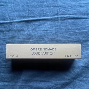 Ombre Nomade parfym från Louis Vuitton 33 ml - Exklusiv parfym från Louis Vuitton, Ombre Nomade, i en elegant glasflaska med svart lock. Flaskan rymmer 33 ml och kommer i en lyxig beige ask med diskret LV-mönster. Doften är känd för sina rika och intensiva noter.
