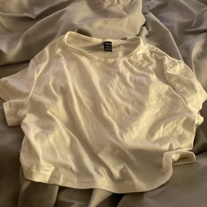 Vit t-shirt  - En basic vit  t-shirt med rund halsringning och korta ärmar. Perfekt för en enkel och avslappnad stil. Tillverkad i mjuk bomull för skön komfort.