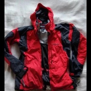Röd och svart vintage sjacka från Marmot. - Säljer en vintage Marmot StormLight Jacket 3Ply Alpinist Gore-tex Parka Ultra Light jacka.   Jackan har mhuva och flera fickor. Dragkedja framtill och justerbar nederkant. Perfekt för utomhusaktiviteter och har meshfoder på insidan för extra komfort.
