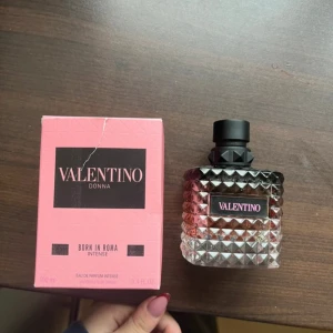 Valentino Donna Born In Roma Intense Eau de Parfum - Lyxig parfym från Valentino med en elegant, rosa och svart kartong. Flaskan är genomskinlig med nitar och svart kork, och rymmer 100 ml. Doften är intensiv och feminin, perfekt för dig som vill sticka ut. Endast testad! 