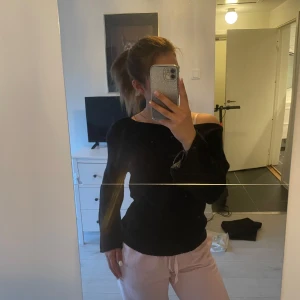 Svart långärmad tröja med båtringning - Säljer en svart långärmad tröja med avslappnad passform och båtringad hals. Perfekt att styla till både jeans och mjukisbyxor. Enkel och stilren design utan synliga detaljer.