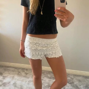 Vita spetsshorts - Säljer ett par vita shorts med flera lager spets och volangdetaljer. De är mini och har en normal passform. Perfekta för sommaren och ger en romantisk look. Från zaras gamla kollektion säljs inte längre 💗