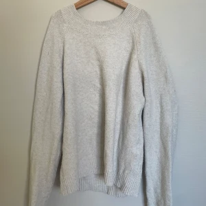 Beige stickad tröja från Vero Moda - Mysig beige stickad tröja från Vero Moda med rund halsringning och ribbade muddar. Perfekt för lager-på-lager och enkel att matcha med olika outfits.