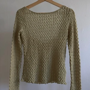 Ljusgrön ribbad topp från NAKD - Ljusgrön långärmad topp från NAKD med ribbad struktur och fyrkantig rygg. Tunn och stretchig i ett vågigt, texturerat material som sitter snyggt och känns bekväm. Aldrig använd, orginalpris 349