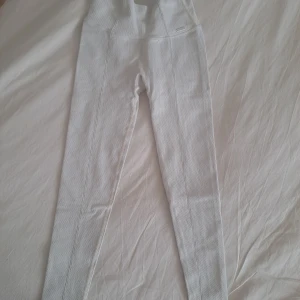 Beiga Aimn leggings med struktur - Säljer ett par beiga leggings från Aimn med snyggt strukturerat tyg och hög midja. De har en tight passform och är perfekta för träning eller chill. Diskret Aimn-logga framtill och sömmar som ger en sportig look.