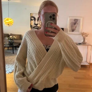 Beige omlottstickad kofta - Supermysig beige kofta med omlott-design och bred v-ringning. Perfekt till hösten!