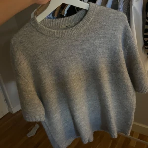 Grå stickad tröja från Gina Tricot - Supermjuk grå stickad tröja från Gina Tricot med korta ärmar, perfekt till hösten 