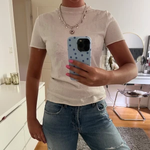 Stickad t-shirt - Enkel och stilren stickad t-shirt med rund hals och korta ärmar. T-shirten har en klassisk passform som sitter snyggt till jeans eller kjol. Perfekt för dig som gillar en clean och fräsch look.