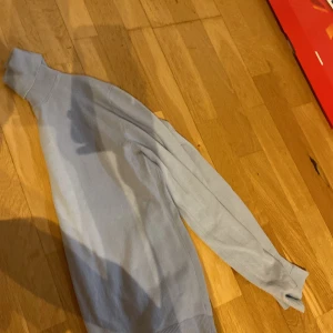 Ljusblå polotröja från MNG - Säljer en stilren ljusblå polotröja från MNG. Tröjan har lång ärm, hög polokrage och är tillverkad i mjukt material som känns skönt mot huden. Perfekt för lager-på-lager och enkel att matcha med jeans eller kjol.