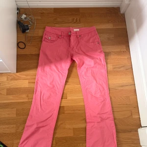 Rosa bootcut byxor från WAXX - Snygga rosa byxor från WAXX med klassisk femficksdesign och raka ben. Byxorna har bälteshällor, knapp- och dragkedjestängning samt silverfärgade detaljer. Perfekta för dig som vill sticka ut med färg. Materialet känns som bomull.