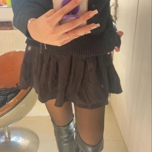 Svart plisserad kortkjol - Supersnygg svart plisserad kortkjol med hög midja och dragkedja i sidan. Kjolen passar alla vibes och är riktigt bekväm. Skulle säga att det passar S/M