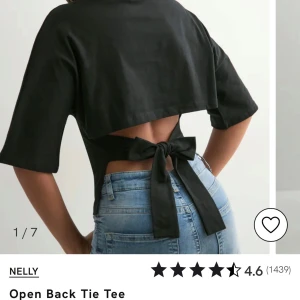 Svart croppad topp med öppen rygg Nelly - Svart croppad topp från Nelly med öppen rygg och bred knytning bak i midjan. T-shirttyp med halvlånga ärmar och snygg, minimalistisk look. Perfekt för dig som vill ha en trendig och edgy stil. Använd max 3 gånger, som ny!!