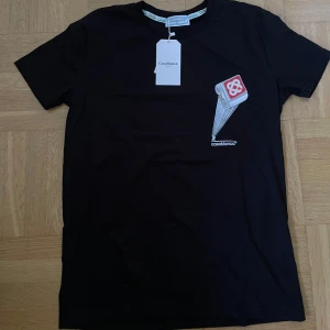 Casablanca t shirt - Svart t-shirt från Casablanca med coolt tryck av en pelare och logga på bröstet och ryggen. Klassisk rund hals och korta ärmar.Perfekt för dig som gillar streetwear med unik design. Tröjan är helt ny och har aldrig använts