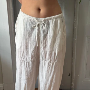 Vita linnebyxor - Säljer ett par luftiga vita linnebyxor med resår och snörning i midjan. Skulle säga att de är perfekta strandbyxor då dem är lite väl see-through. Storlek L men på den större sidan.