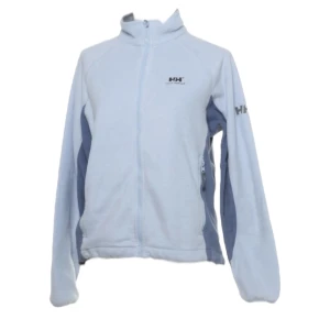 Fleece från Helly Hansen - Ljusblå fleece från Helly Hansen. Mörkare blå detaljer längs sidorna och ärmarna. Supersnygg och skön i bra skick, men nopprig, därav lågt pris 🙏🏼Storlek M men tycker den sitter som en S