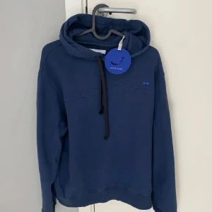Blå hoodie från Jacob Cohën - Säljer en snygg blå hoodie från Jacob Cohën med broderad logga på bröstet. Tröjan har andvänts en del men tagits väl hand om. Snörena har jag tagit bort då jag ansåg att de inte såg bra ut. Köpt här på Plick för ca 2500 kr, sälja för 600! Endast tröjan medföljs. Hör av er vid frågor eller funderingar!