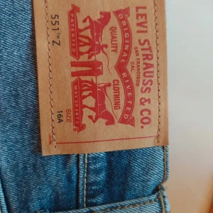 Levi's 551Z autentiska raka jeans - Helt oanvända. Klassiska blå jeans från Levi's modell 551Z med autentisk rak passform och stretch. Jeansen har fem fickor, gylf med dragkedja och knapp, samt den ikoniska läderpatchen bak i midjan. Perfekta för en avslappnad stil.