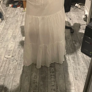 Vit långkjol från Gina Tricot - Säljer en vit långkjol från Gina Tricot med volangdetaljer. Kjolen har en luftig och flowy känsla, perfekt för varma dagar. Resår i midjan för extra komfort och snygg passform. Endast använd några gånger förra sommaren, köptes då för antingen 399 eller 499 kommer tyvärr ej ihåg. Den är i super bra skick i storlek S men passar mej perfekt i längden o jae cirka 167