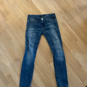 Blå skinny jeans från Replay - Säljer ett par blå skinny jeans från Replay, modell Luz. Jeansen har klassisk femficksdesign, dragkedja och knapp i midjan samt snygga slitningar och tvättade detaljer. Perfekta för dig som gillar en tight passform och stilren look.