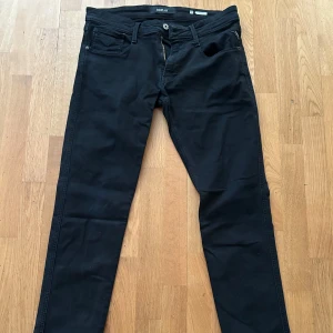 Svarta anbass jeans från Replay - Säljer ett par svarta jeansbyxor från Replay. Storlek: W33 L34. Byxorna har blivit använda och tvättade. Skick 7.5/10 Pris kan alltid diskuteras vid snabb affär!