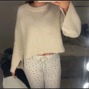 Beige croppad stickad tröja - Mysig croppad stickad tröja i beige med rund halsringning och långa ärmar. Tröjan har en relaxed passform och ribbad struktur, perfekt för lager-på-lager och chill dagar.