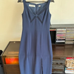 Marinblå långklänning  - Marinblå bal/aftons/finklänning från Nitelite Della Roufogali.   Liten slits framtill. Små meshdetaljer fram. Lång. Elegant design och smickrande silhuett.   Säljer då den tyvärr är för stor för mig. Nyskick.