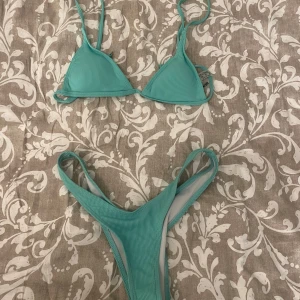 Turkos ribbad bikini - Säljer en turkos bikini med ribbat material. Överdelen har trekantsformade kupor och smala axelband, underdelen är högt skuren. Perfekt för stranden eller poolen!