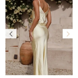 Ljusgul långklänning i satin med smala axelband - Säljer en elegant ljusgul långklänning i satin med smala axelband och v-ringning. Klänningen har en figurnära passform och en stilren, minimalistisk design som ger en lyxig känsla. Perfekt för sommarens speciella tillfällen. Använd 1 gång endast. 