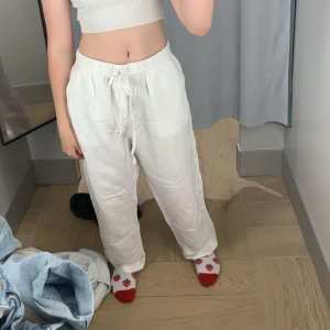 Vita linnebyxor med snören - Säljer ett par vita linnebyxor med avslappnad passform och knytning i midjan. Har använt de i ungefär 2 sommrar så de är inte i nyskick! Pris kan diskuteras. Passar som en S-M 