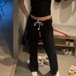 Lågmidjade marinblå linnebyxor från Roxy - Marinblå linnebyxor från Roxy med vita detaljer. Storleken är S och jag på bilden är 166 och så sitter de på mig. Byxorna är lågmidjade!