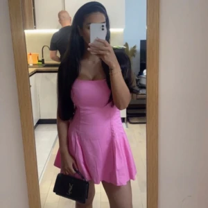 Rosa kortklänning med axelbandslös design zara - Säljer en söt rosa kortklänning med axelbandslös och figurnära överdel samt utsvängd kjol. Perfekt för sommarens alla tillfällen. Klänningen har en enkel och stilren look.