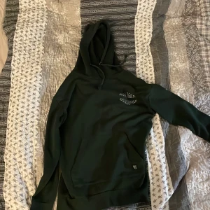 Svart hoodie från Saligia/Lager 157 - Säljer en mörk grön hoode barn storlek X-small från Saligia/Lager157