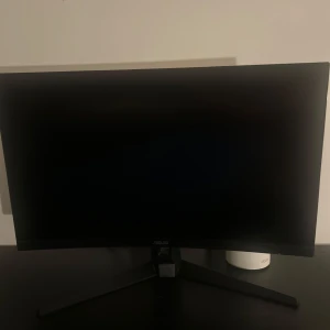 Svart datorskärm från ASUS - Säljer en stilren svart datorskärm från ASUS med böjd design och smala kanter. Skärmen står på ett stabilt stativ med breda ben och passar perfekt för gaming eller arbete. Enkel att koppla in till datorn. Köpt för 5000
