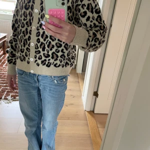 Leopardmönstrad kofta i beige och svart - Säljer en snygg leopardmönstrad kofta i beige och svart med knappar framtill. Tröjan är stickad och har långa ärmar.passar mig som kan ha strl xxs xs s