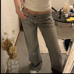 Straight Jeans  - Säljer ett par gråa straight jeans från 7 For All Mankind. Jeansen har klassisk femficksdesign, låg midja och snygga detaljer på bakfickorna. 🩶 Innerbenslängd: 84 cm MidjeMått: 47 cm. Jag är 166 cm och bär vanligtvis storlek S för referens! 