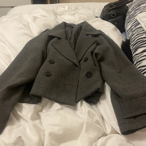 Grå kappa - Säljer en grå basic kappa för 300kr ny pris 500kr. Bara använd fåtal gånger, säljer då storleken inte passar