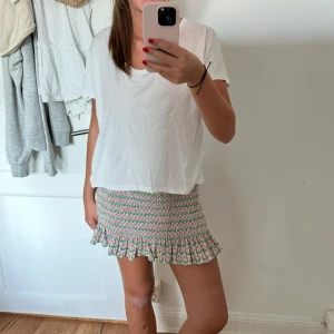 Blommig tubtopp/ kjol - Säljer en söt tubtopp/kjol med ribbad passform och volangkant nertill. Den har ett blommigt mönster i rosa, grön och vit. Egentligen är det en kjol men funkar bra för båda 🤗💕 