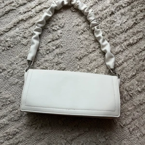 Handväska  - En väska som är använd en gång på ett bröllop och har nu inte behov av den. Nypris 399