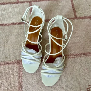 Sandaletter - Duffy - Säljer dessa högklackade sandaletter från Duffy, använda endast en gång. Köpt 2024, original pris - 700kr. De är för små i storleken för mig.  Sandaletter i skinnimitation med smala remmar • Ankelrem med metallspänne på sidan • klackhöjd - 5cm