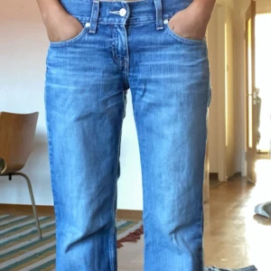 Levi's Marissa blå jeans - Säljer ett par snygga Levi's Marissa jeans i blått. De har en bootcut-stil och är lågmidjade, vilket ger en väldigt fin passform. Perfekta jeansen och de saknar någon defekt!! på första bilden står jag på tå för att bättre visa hur jeansen sitter 💓 