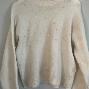 Stickad tröja med pärlor detaljer - Mysig stickad tröja med pärlor som detaljer❣️ passar perfekt till en basic outfit och nu inför hösten. Lite nopprig men knappt använd!