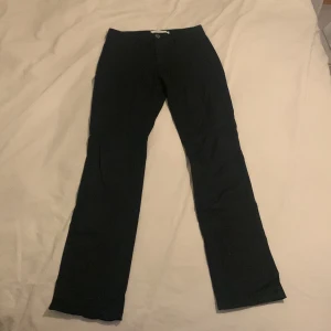 Svarta byxor från Stockh LM - Säljer ett par svarta byxor från Stockh LM i storlek 34. Byxorna har en stilren design med dragkedja vid fickorna och en rak passform. Perfekta för både vardag och fest!